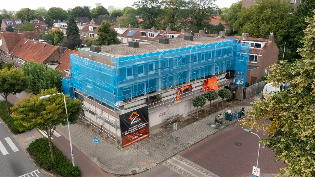 Appartementencomplex met bedrijfsruimte in de steigers tijdens gevel- en dakrenovatie door Dak en Gevel Renovaties
